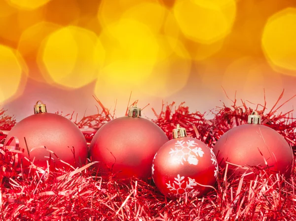 Weihnachten rote Kugeln auf verschwommenem orangefarbenem Hintergrund — Stockfoto