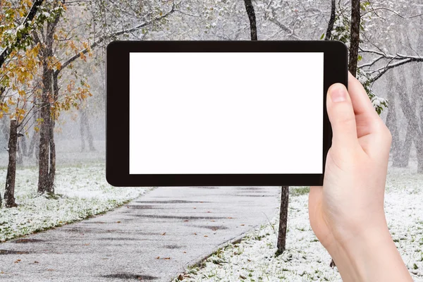 Tablet pc a první sníh v městském parku — Stock fotografie