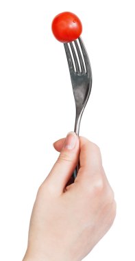 çatal saplanmış bir kırmızı kiraz domates el ile