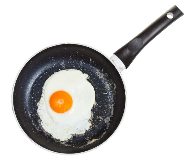 Vista superior de un huevo frito en frypan negro aislado — Foto de Stock