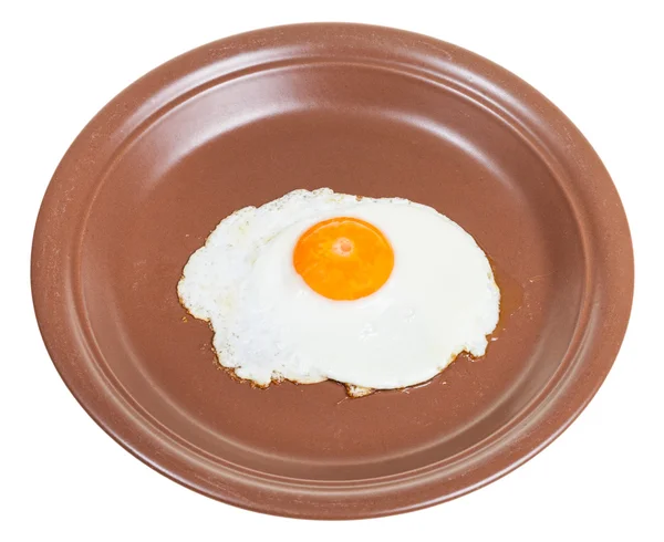 Jedna smažená vejce na hnědá Keramická deska izolovaná — Stock fotografie