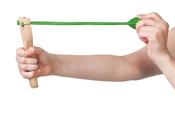 Hands pulling green band of wooden slingshot — Stock Photo, Image