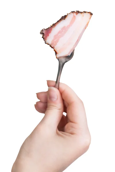 Garfo de jantar com pedaço empalado de bacon na mão — Fotografia de Stock