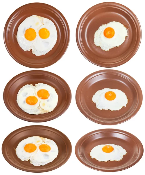 Ensemble de assiettes brunes avec un et deux œufs frits — Photo