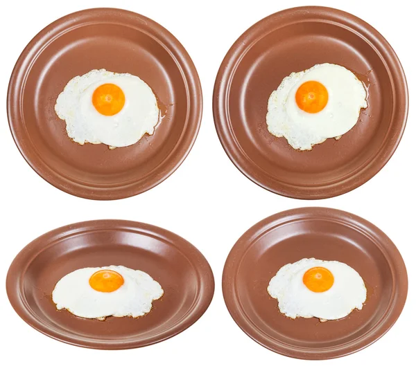 Set of brown plates with one fried egg isolated — Stock Photo, Image