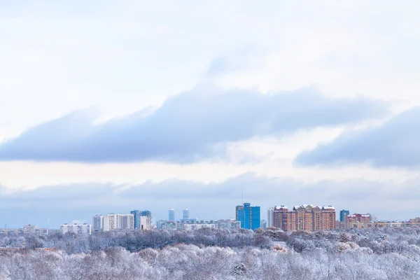 Blue clouds over urban park and town in winter — Stock Photo, Image