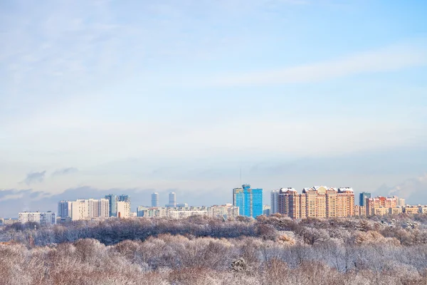 Nubes blancas en cielo azul sobre bosque de nieve y ciudad —  Fotos de Stock