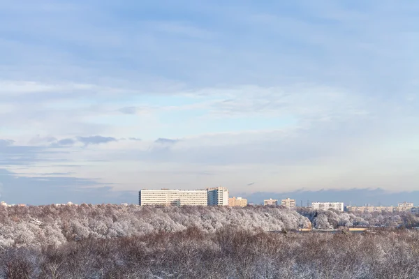 Nuages bleus dans le ciel bleu sur la forêt de neige et la ville — Photo