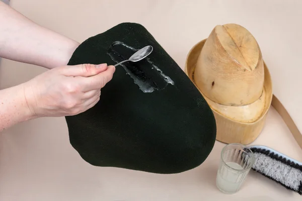 Hatter applies an adhesive a felt hood for shaping — Stock Photo, Image