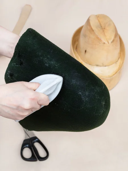 Chapeleiro colando um capuz de feltro para moldar no manequim — Fotografia de Stock