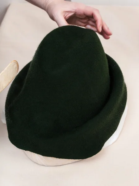 Hatter corrige um capuz de feltro no chapéu-bloco para moldar — Fotografia de Stock