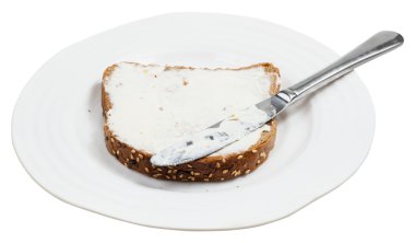 tahıl ekmek peynir yayıldı ve plaka üzerinde bıçak ile