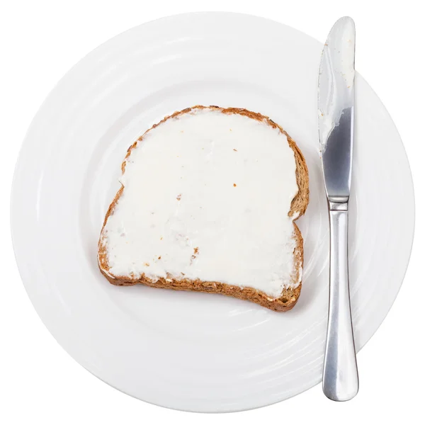 Top view of bread and spread with knife on plate — Stock Photo, Image