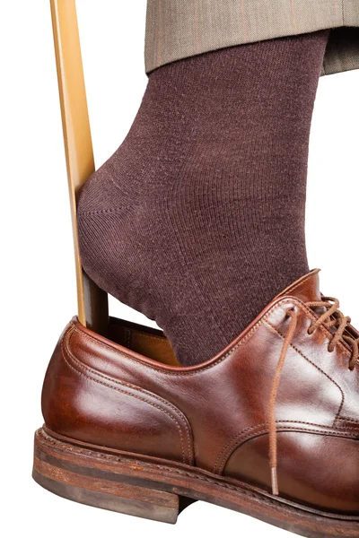 Mann zieht braunen Schuh mit Schuhhorn an — Stockfoto