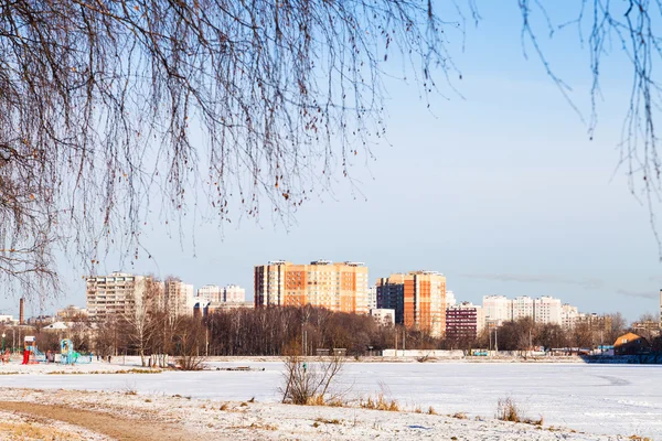 Frozen lake and urban houses in winter — Stock Photo, Image