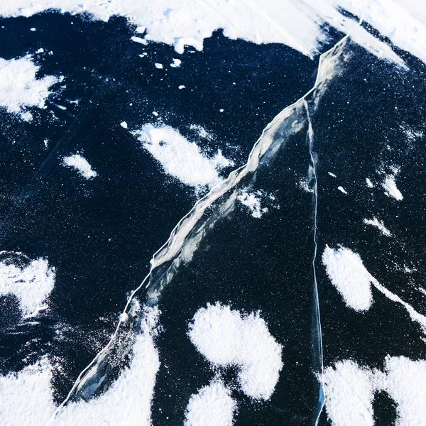 Crack in ice on surface frozen river in winter — Stock Photo, Image