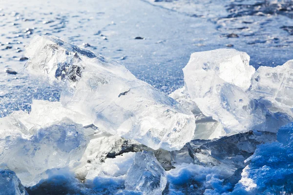 Blocos de gelo na borda do buraco de gelo no lago congelado — Fotografia de Stock