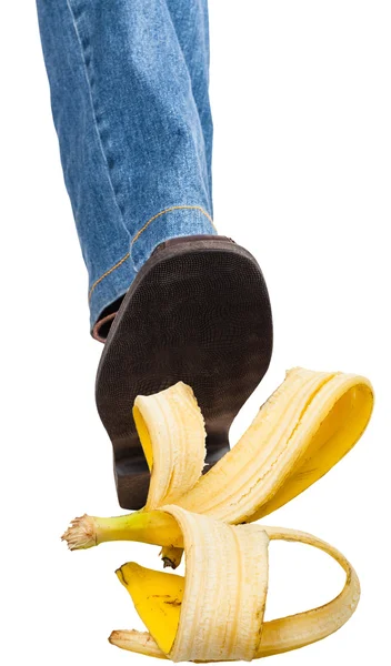 Rechtes Bein in Jeans und Schuh tritt auf Banane — Stockfoto