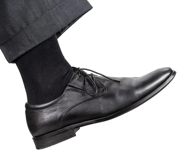 Male right leg in black shoe takes a step — Stock Photo, Image