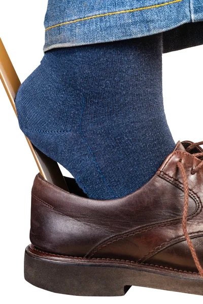 Man close-up zet op bruine schoenen met behulp van schoen hoorn — Stockfoto