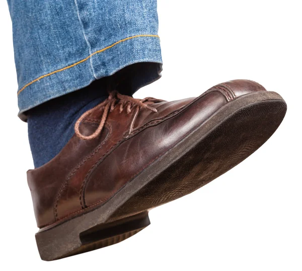 Schritt des männlichen rechten Beines in Jeans und braunem Schuh — Stockfoto