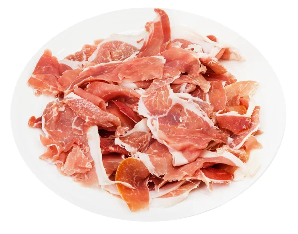 Crudo di prosciutto tagliato a fette sottili su piatto isolato — Foto Stock