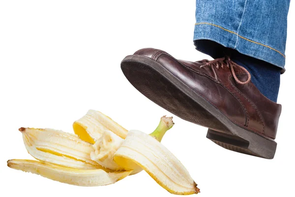 Linker Fuß in Jeans und Schuh rutscht auf Bananenschale — Stockfoto