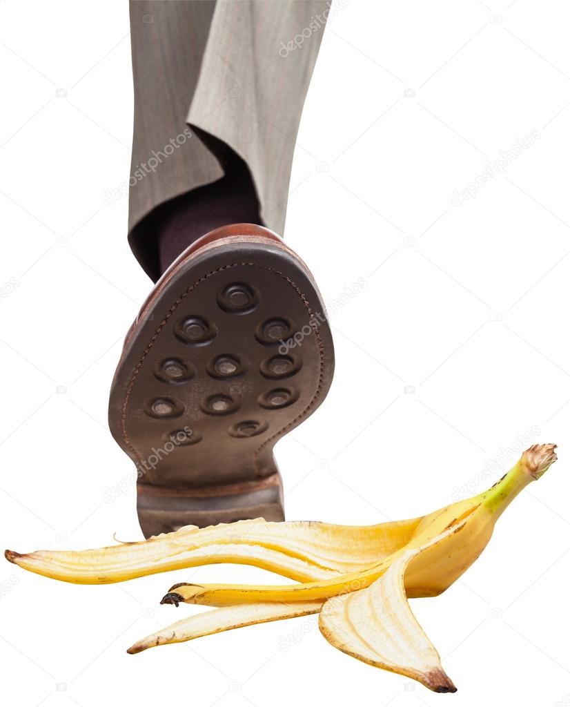 leg in right brown shoe stepping on banana peel