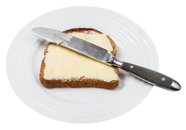 Bread and butter with table knife on white plate — Stock Photo, Image