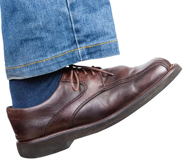 Right foot in jeans and brown shoe takes a step — Stock Photo, Image