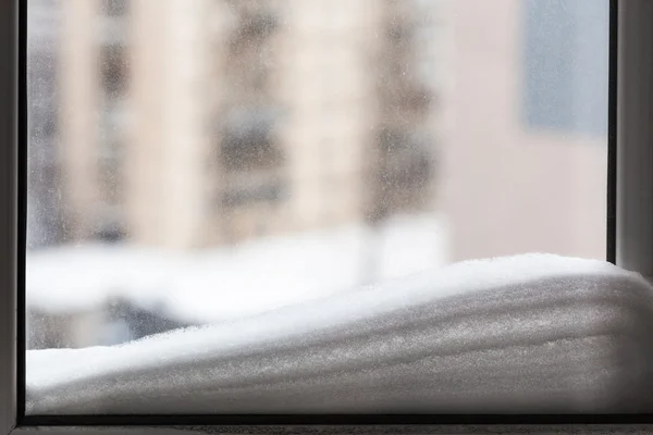 Snö på fönsterrutan och hus på bakgrund — Stockfoto