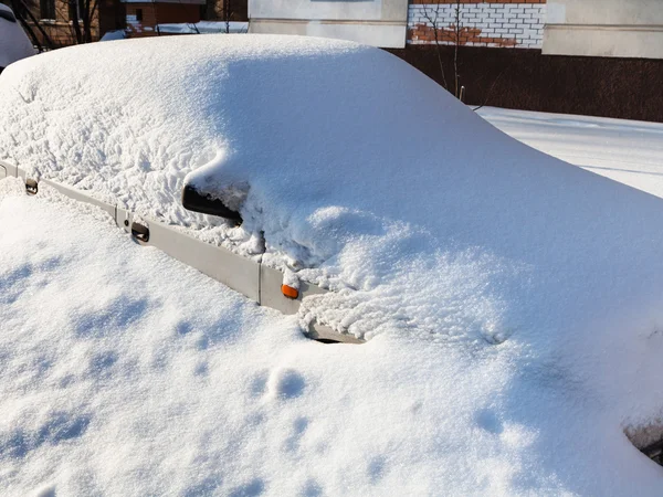 White car under snowdrift in parking lot — Stock Photo, Image