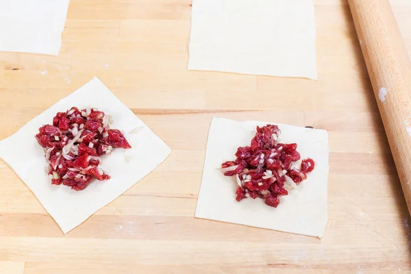 Carne tritata e cipolla su pezzi di pasta arrotolata — Foto Stock