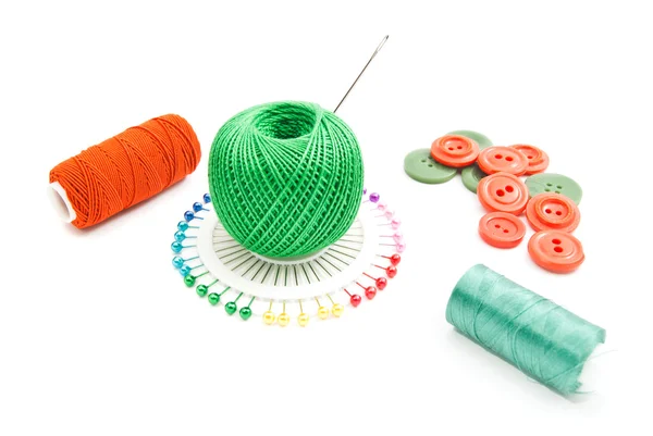 Green and red thread, pins and buttons — Stock Photo, Image