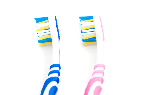 Cepillos de dientes de color rosa y azul sobre blanco — Foto de Stock