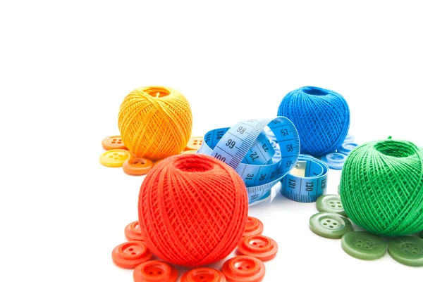 Quatro bolas coloridas de fios, botões e medidor — Fotografia de Stock