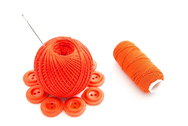 Red plastic buttons, needle and thread — Stock Photo, Image