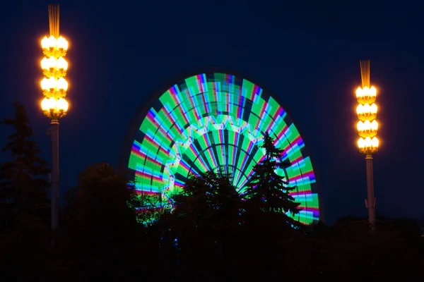Grande roue colorée dans un parc du soir d'été — Photo