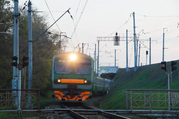 Vlak přijíždí na železniční přejezd v městě — Stock fotografie