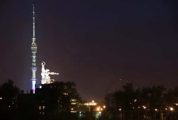 Башня, памятник и колесо обозрения в вечернее время — стоковое фото