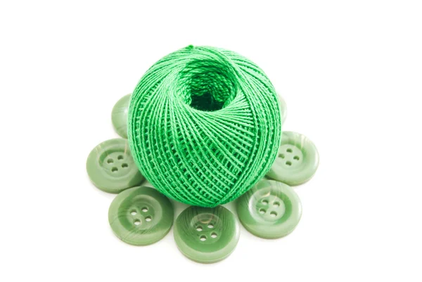Green plastic buttons and thread on white — Stock Photo, Image