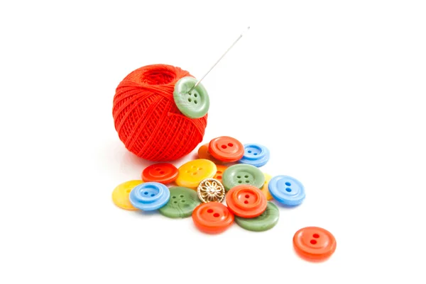 Needle, plastic buttons and red thread — Stock Photo, Image