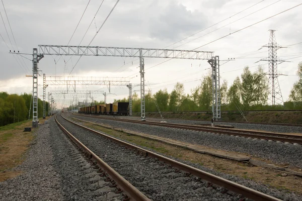 Trainen op de tracks in bewolkte dag — Stockfoto