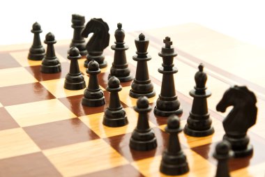 bir satranç tahtası üzerinde siyah satranç figürleri