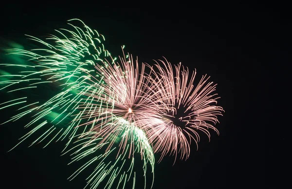 Groen en roze vuurwerk in de hemel — Stockfoto