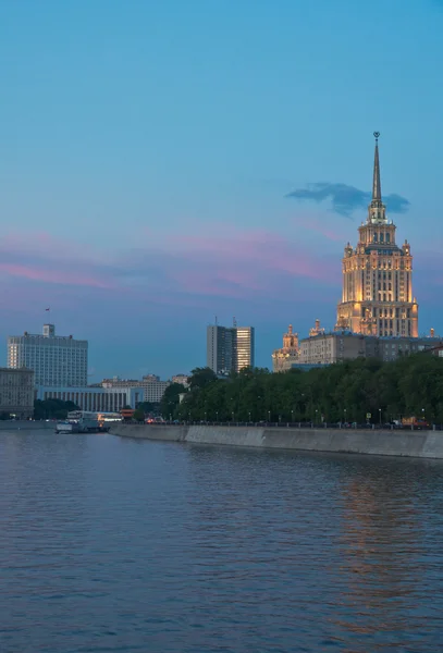 Buildings on banks of river at sunset — Stock Photo, Image