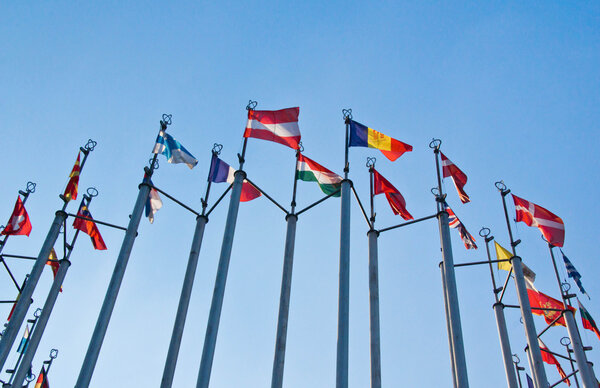 different flags on background of sky