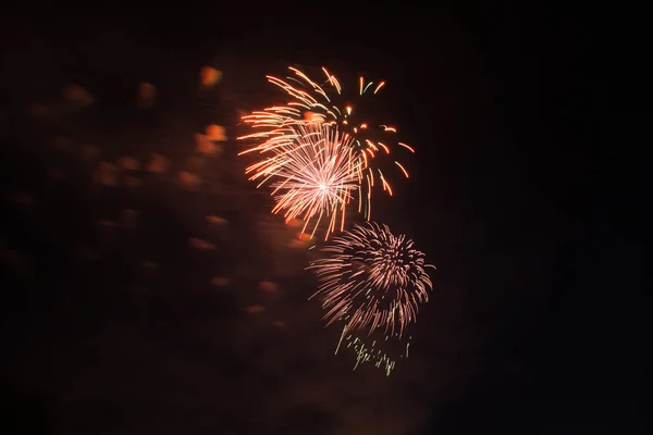 Oranje en rode vuurwerk in de donkere hemel — Stockfoto