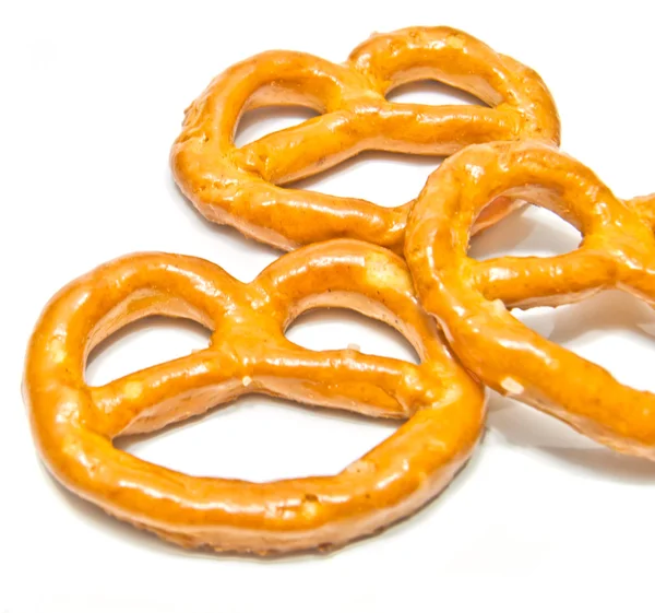 Tre pretzel salati primo piano su bianco — Foto Stock