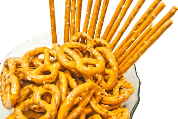 Sabrosos pretzels salados y palitos de pan en un plato —  Fotos de Stock